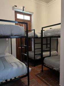 a group of bunk beds in a room with a window at La Félicité Hostel in Salta
