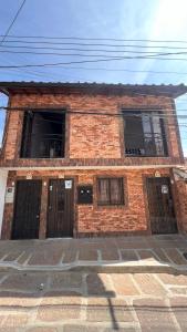 a brick building with two windows and two doors at Apto. en zona céntrica con vista panorámica al pueblo in San Gil
