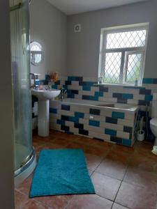 Un baño con bañera, lavabo y ducha. en Long Acre, Holiday rental in Central Manorhamilton, Leitrim, en Leitrim 14 fotos más