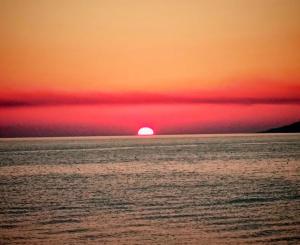 a sunset over the ocean with the sun in the horizon at La Foggia seaside paradise in Siculiana
