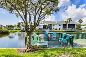 a group of chairs sitting next to a lake at Condo with Patio and Resort Amenities in Fort Pierce! in Fort Pierce