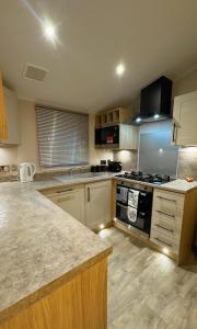 a kitchen with a stove and a counter top at Carlisle CAMELOT HOLIDAY PARK CA65SZ MANOR in Longtown