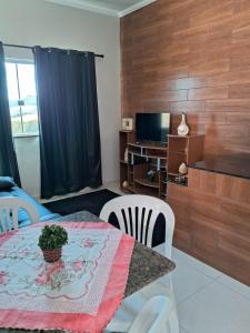 サン・ロウレンソにあるApto Vista das Montanhasのテーブルと椅子とテレビのあるリビングルーム