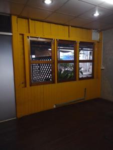 a yellow wall with two windows in a room at 362 สวนอ้อย5 in Dusit +5 photos