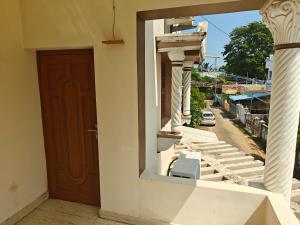 a door of a building with a chair on a balcony at Treva Blue Nest in Karaikal