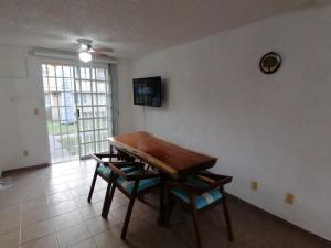 a dining room with a wooden table and chairs at Casa Cayo in Ixtapa