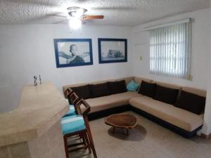 a living room with a couch and a table at Casa Cayo in Ixtapa