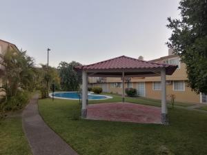 a backyard with a gazebo and a pool at Casa Cayo in Ixtapa