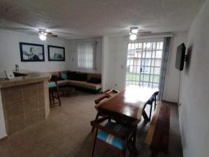 a kitchen and living room with a table and a couch at Casa Cayo in Ixtapa