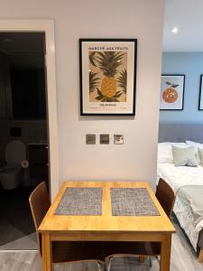 ein Esszimmer mit einem Tisch und einem Bett in der Unterkunft Stylish studio apartment, One Thames Valley in Bracknell
