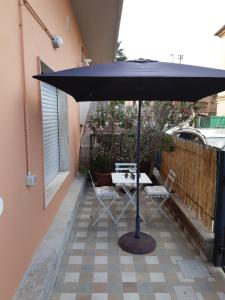 a table and chairs under an umbrella on a patio at Maison Paola in Giulianova