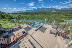una terraza con bañera de hidromasaje y 2 sillas. en CLIFF CABIN Family Friendly|Hot Tub|Spectacular Views, en Fairmont Hot Springs