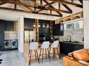 a kitchen with black cabinets and a kitchen island with stools at Villa 206 Clarens Golf Estate in Clarens