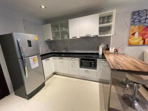 a kitchen with a refrigerator and a table in it at Emerald Terrace Condo 42- 1 Bed Pool in Patong Beach