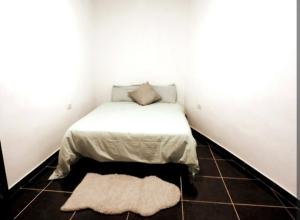a small bedroom with a bed in a corner with a rug at Casa La Ladera in Hermigua