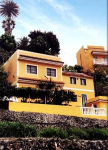 a yellow house on the side of a hill at Casa La Ladera in Hermigua