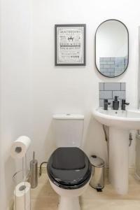 a bathroom with a black toilet and a sink at 5min to Huddersfield Royal Infirmary Hospital in Lindley
