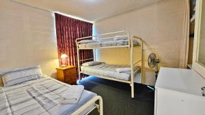 カルバリにあるRiverview Holiday Apartment 77 - Kalbarri WAの二段ベッド2台とシンクが備わる客室です。