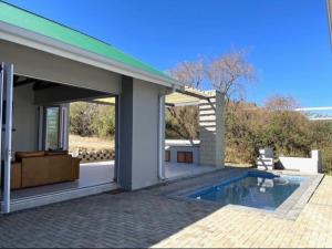 a house with a swimming pool next to a building at Villa 206 Clarens Golf Estate in Clarens