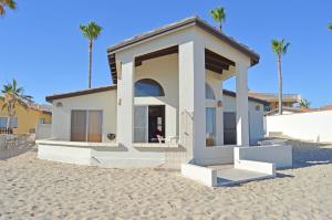 a small house on the beach with palm trees at Playa Romantica in Puerto Peñasco