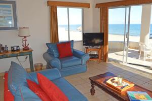 a living room with a blue couch and a television at Playa Romantica in Puerto Peñasco