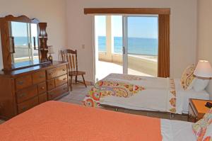 a bedroom with a bed and a dresser with a mirror at Playa Romantica in Puerto Peñasco