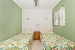 two beds in a room with green walls at La Gaviota in Puerto Peñasco