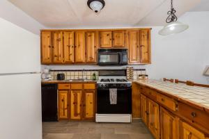 a kitchen with wooden cabinets and a black stove top oven at Paradise Villa #10 in Playa Encanto