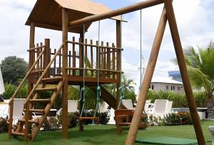 a wooden playground with a wooden swing set at Flat Super Confortável em Porto de Galinhas in Porto De Galinhas