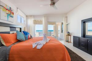 a bedroom with an orange bed with a view of the ocean at La Perla in Playa Encanto