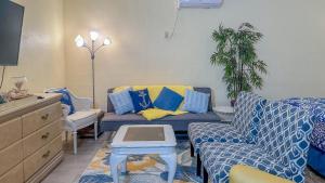 een woonkamer met blauwe en gele kussens en een bank bij Vista de Oro in Puerto Peñasco +17 foto's