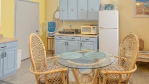 een keuken met een glazen tafel en stoelen en een koelkast bij Vista de Oro in Puerto Peñasco