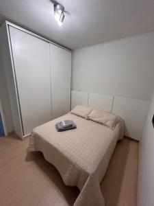 a bedroom with a bed with a blanket on it at Ap Novo Parque Anchieta - Top in Pelotas