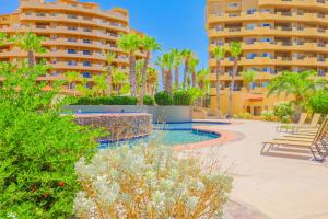 un complejo con piscina, palmeras y edificios en Bella Sirena D802, en Puerto Peñasco