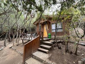 a log cabin with a staircase leading to a house at La Bella Durmiente in San Alfonso