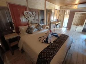 una camera da letto con un letto con un uccello sopra di Yogi Beach Cabin ad Amed
