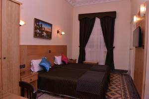 a bedroom with a large bed and a large window at Hotel Continental in Tangier
