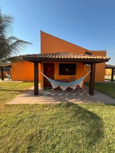 a house with a hammock in front of it at Pousada e restaurante Jardim do Cerrado MT in Estivado +23 photos