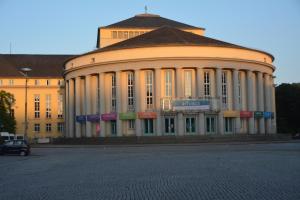 a large white building with a sign in front of it at GQ Deluxe Apartment in Saarbrücken