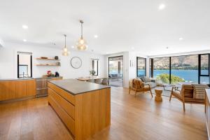 eine offene Küche und ein Wohnzimmer mit Blick auf das Wasser in der Unterkunft Lakeside Luxury in Wanaka