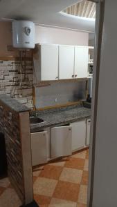 Una cocina con gabinetes blancos y un fregadero. en Appartement aréna, en Oujda