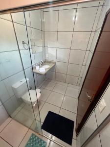 a bathroom with a shower and a toilet and a sink at Pousada e restaurante Jardim do Cerrado MT in Estivado
