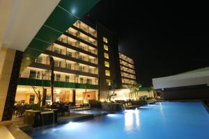a large building with a swimming pool at night at Dalton Hotel Makassar in Makassar