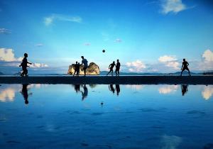 a group of people playing soccer on the beach at Thanya Beach Resort - SHA Plus in Ko Ngai