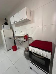 a small kitchen with a stove and a refrigerator at Prestige Loft in Petrolina