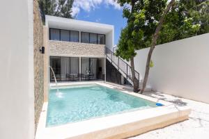 a swimming pool in front of a house at Casa Itzae Hotel Boutique in Mérida
