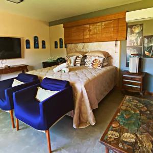 a bedroom with a large bed and blue chairs at Aloe Hotel Boutique in Prado