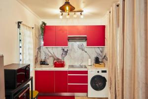 a kitchen with red cabinets and a washing machine at Maroni Oasis in Saint-Laurent du Maroni