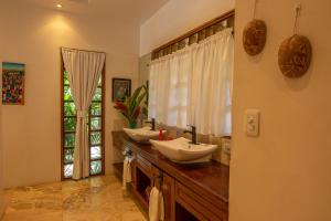 a bathroom with two sinks on a counter with a window at Casa Ambar in Puerto Viejo +39 photos