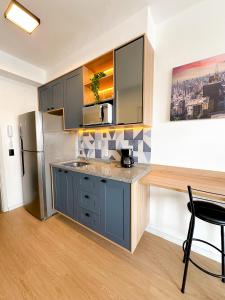 a kitchen with blue cabinets and a stainless steel refrigerator at Blue Apto Automatizado Moderno in São Paulo +61 photos